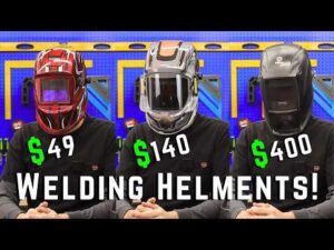 Three people wearing welding helmets priced at $49, $140, and $400 sit at a table. Large text reads “WELDING HELMETS!” in front of them.